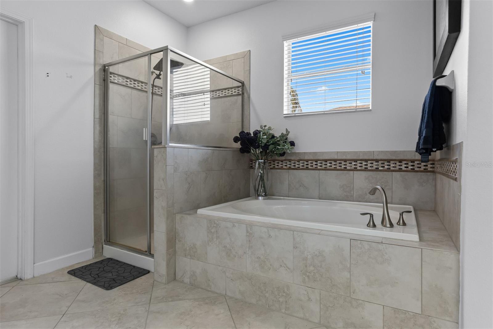 Primary bathroom featuring a large soaking tub with custom tile surround.