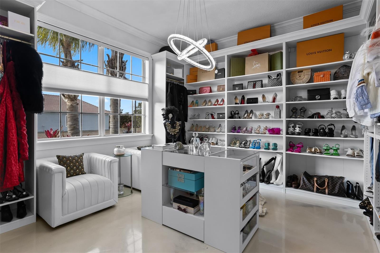 High-end boutique-style closet organization featuring integrated shelving and floor-to-ceiling storage.
