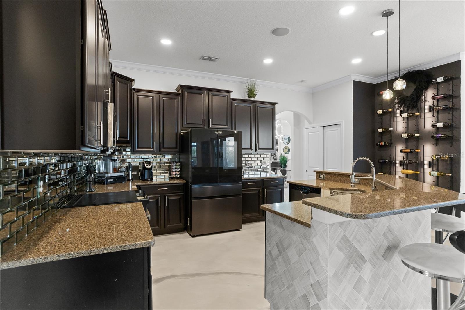 Kitchen view highlighting the adjacent custom wine wall and high-end appliances.