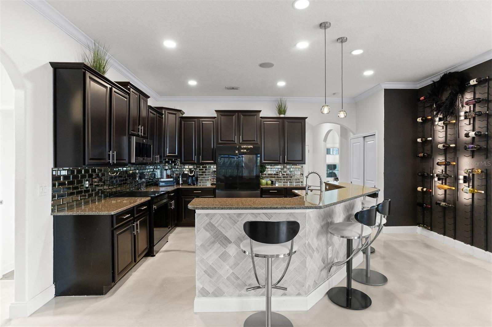 Wide kitchen shot showing the breakfast bar and the designer LED wine wall display.