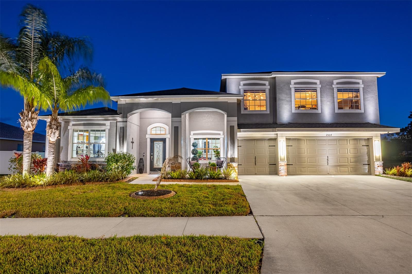 Night view of 2504 Cumberland Cliff Dr with professional exterior uplighting.