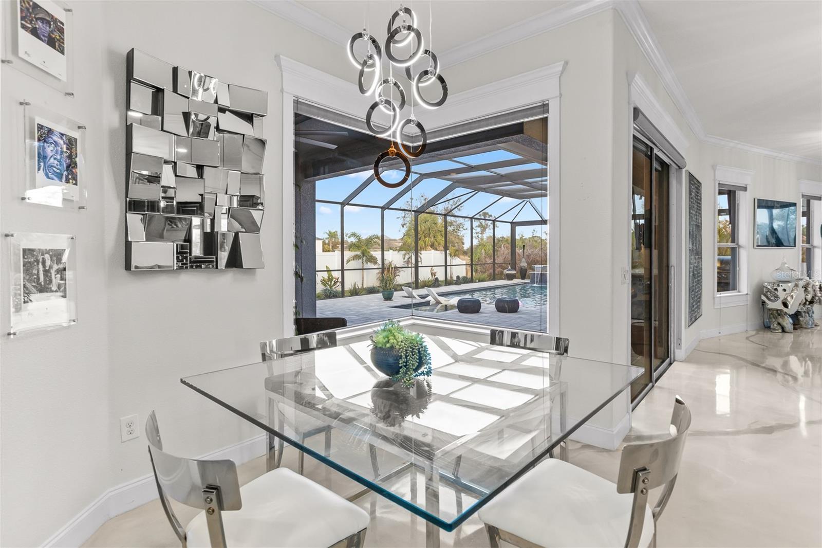 Angled view of the kitchen featuring the breakfast bar, pendant lighting, and high-gloss floors.