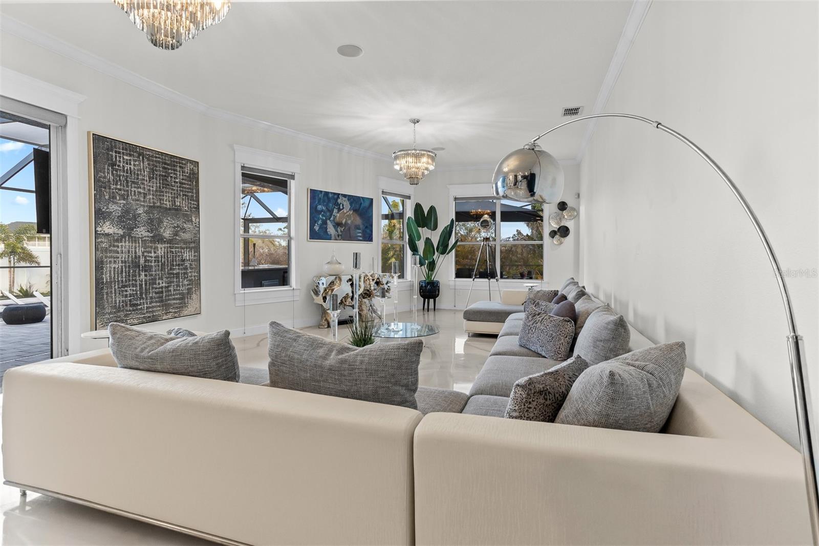 Wide-angle view of the luxury living room showing the lanai access and high-gloss floors.