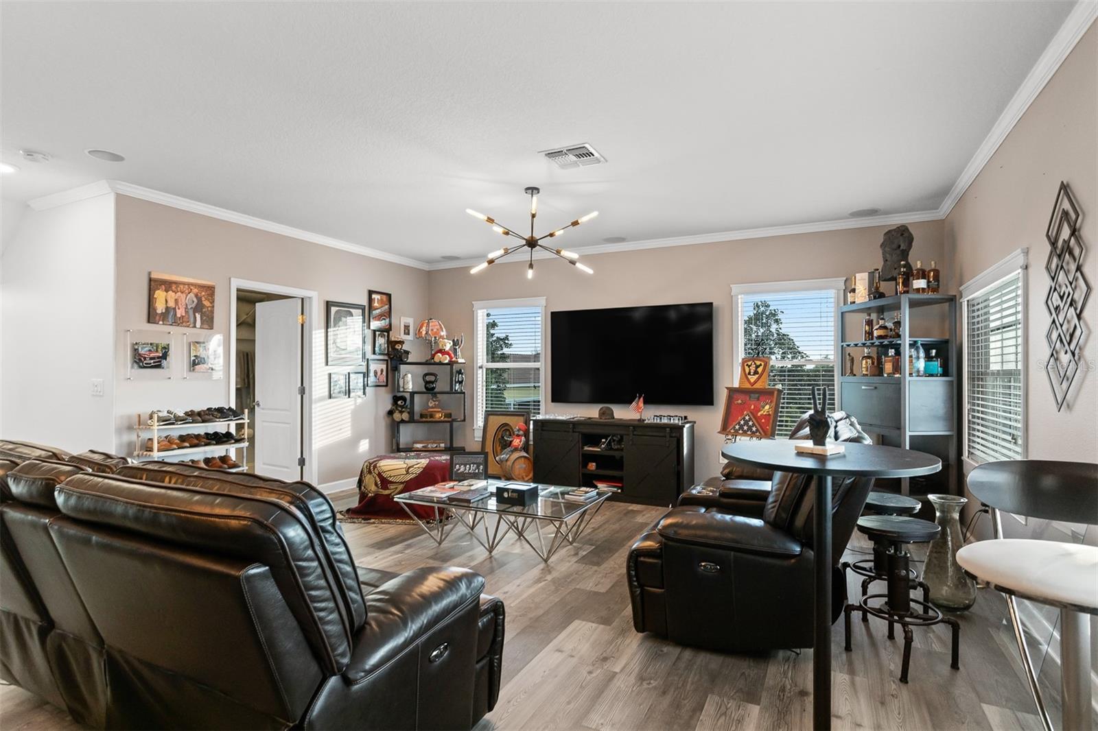 Spacious upstairs media loft with leather theater seating and modern decor.