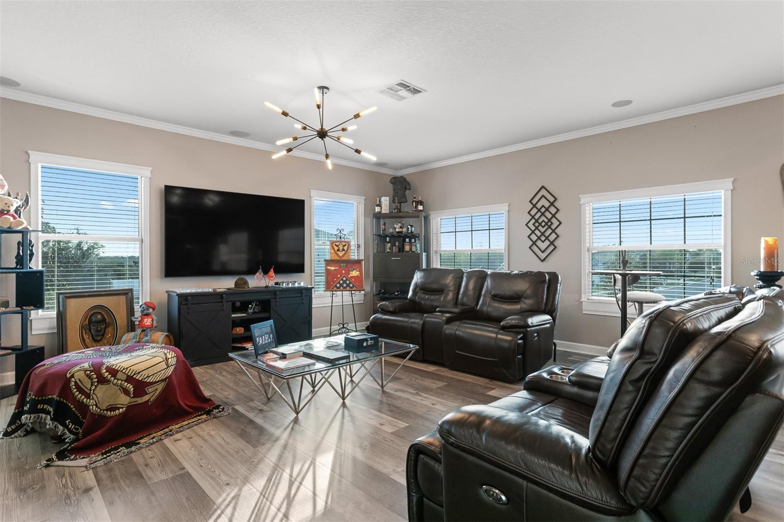 Spacious upstairs loft configured as a home theater with leather reclining seating.