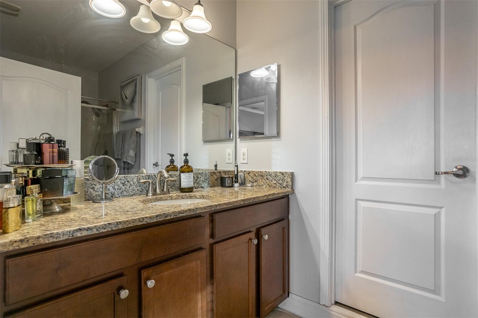 Spacious master bathroom vanity with granite tops and ample storage.