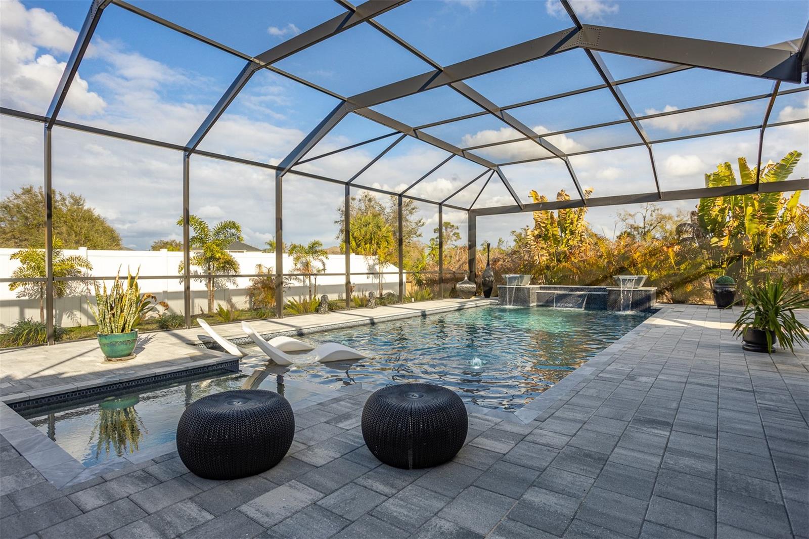 Pool view highlighting the tiered stone water features and textured pavers.