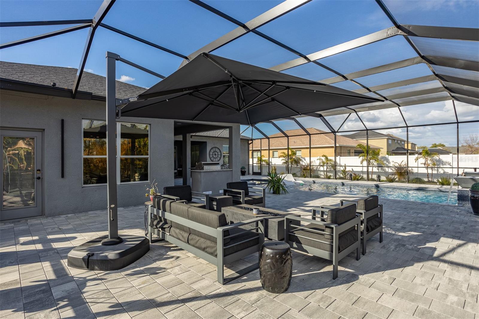 Screened lanai featuring a modern fire pit and lounge area.