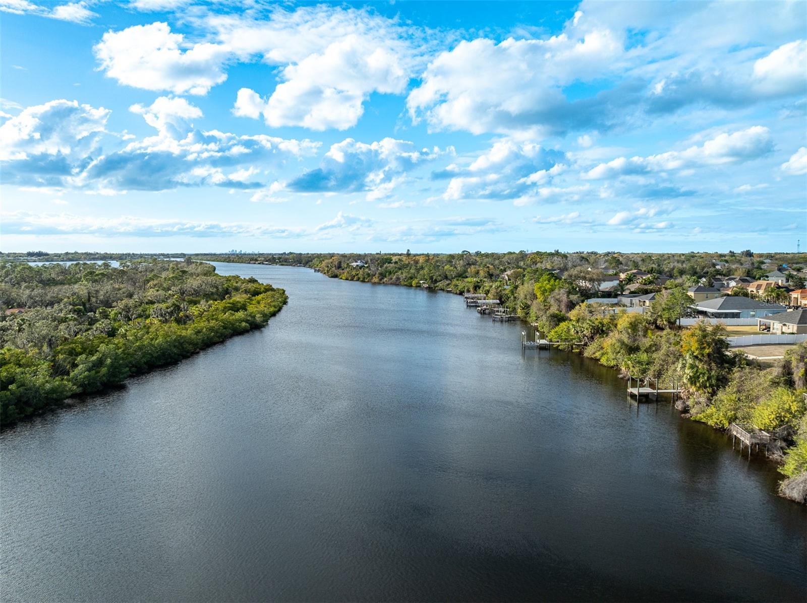 High-altitude shot showing the river bend and the luxury waterfront community.