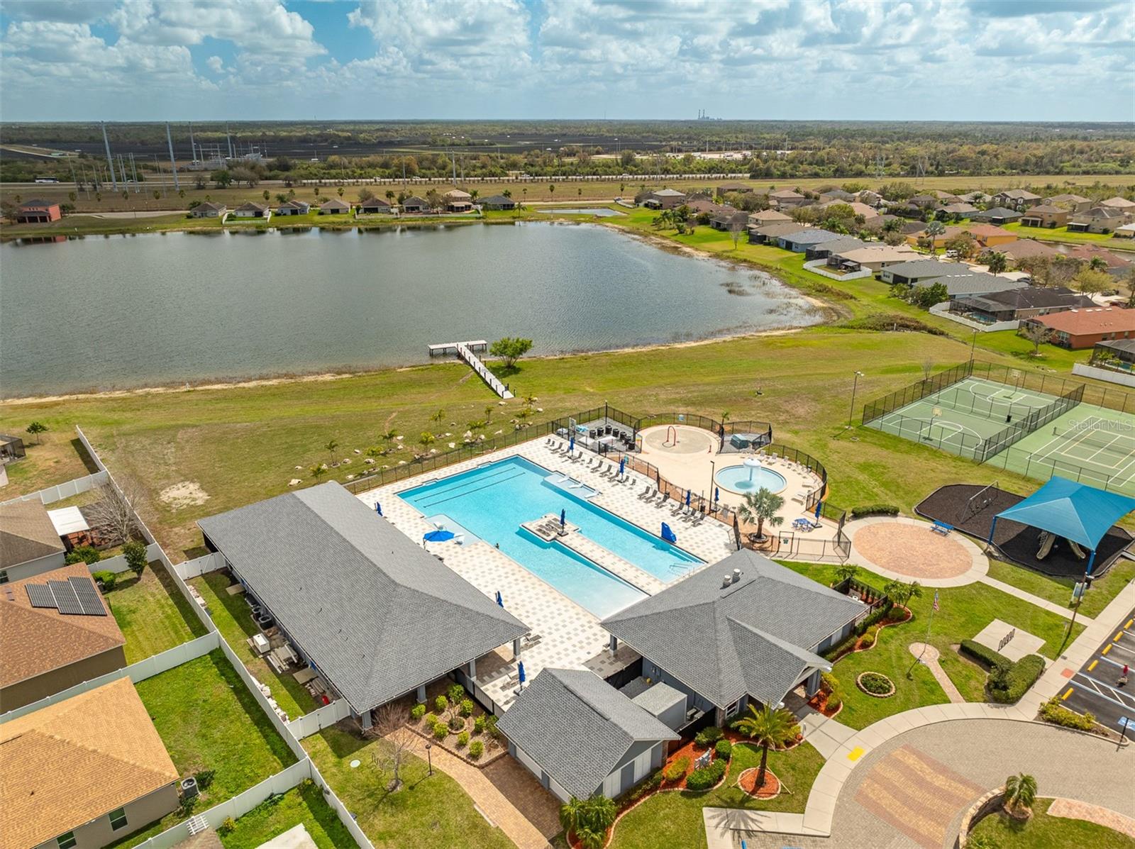 Large resort-style swimming pool with splash pad and sun deck in River Bend.