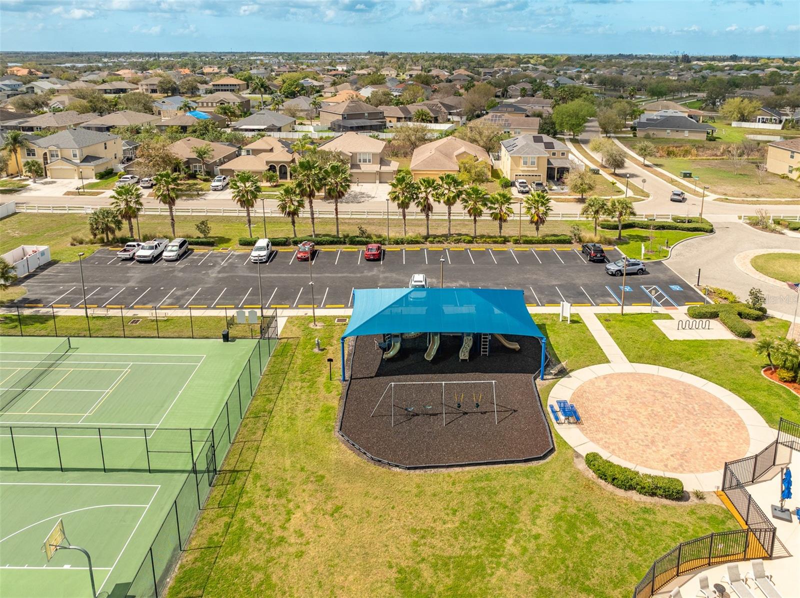 Neighborhood amenities featuring a shaded playground and professional tennis courts.