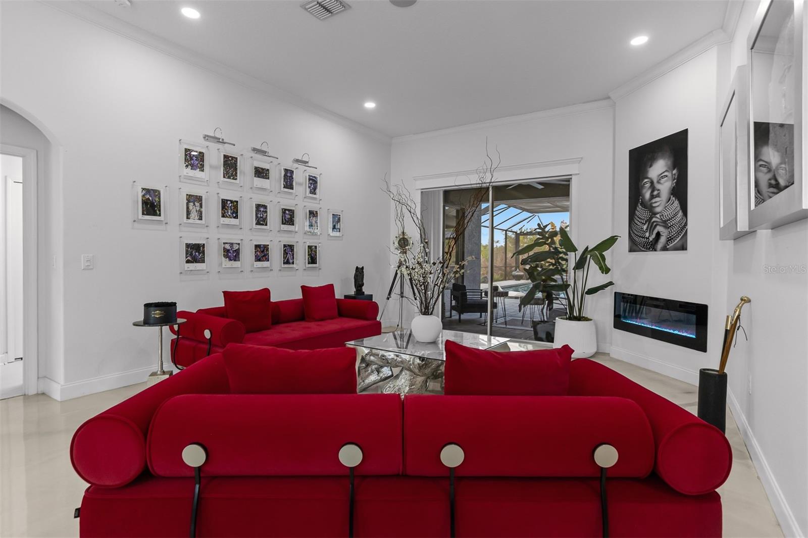 Great room view highlighting the indoor-outdoor flow toward the screened pool and lanai.