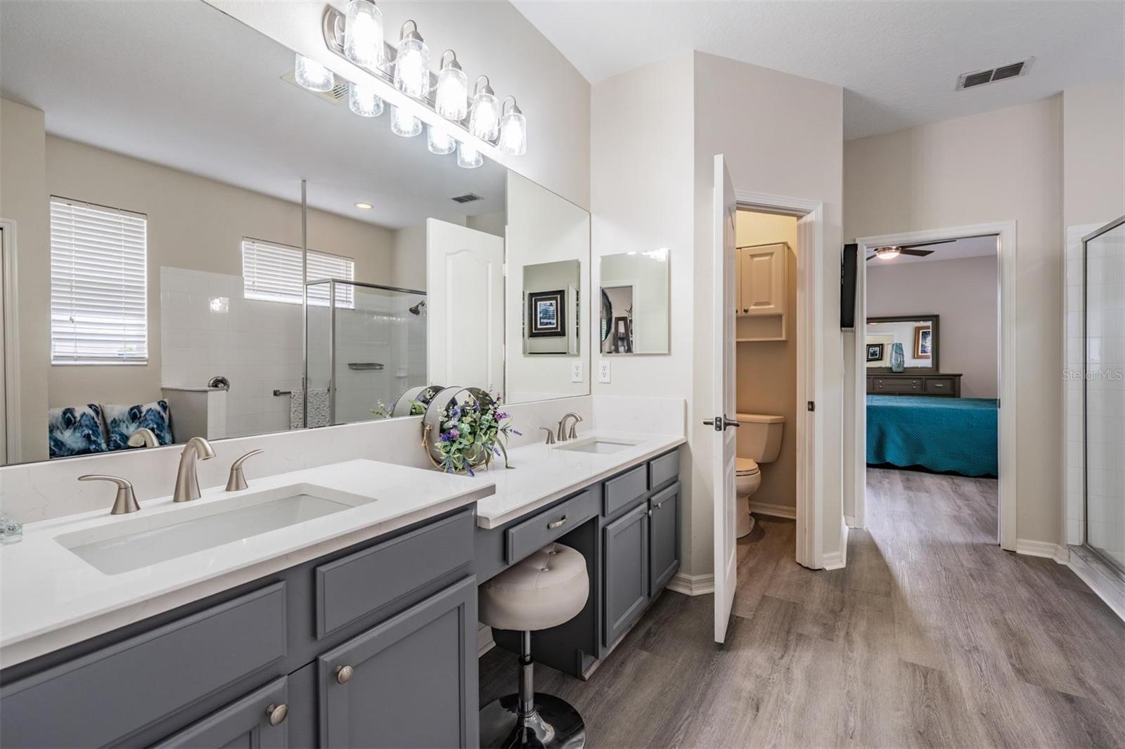 Primary bathroom with vanity seating and a water closet
