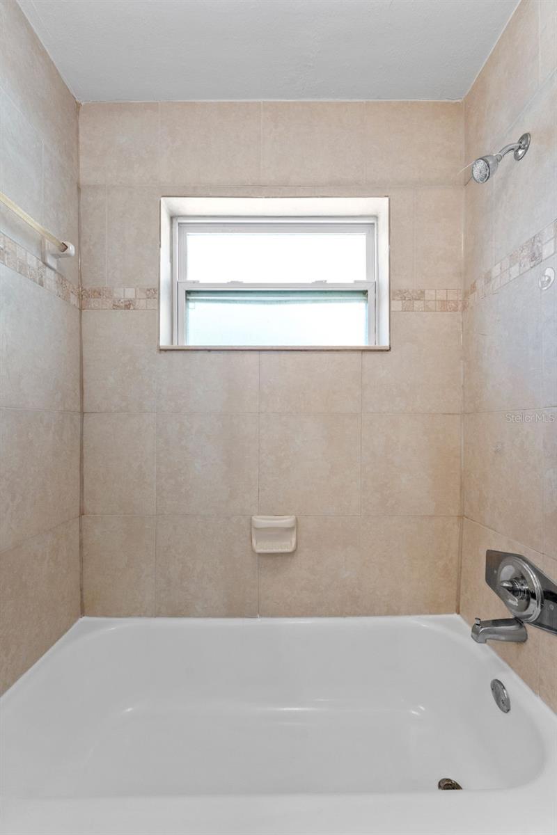 Hall bathroom featuring a convenient tub-shower combo