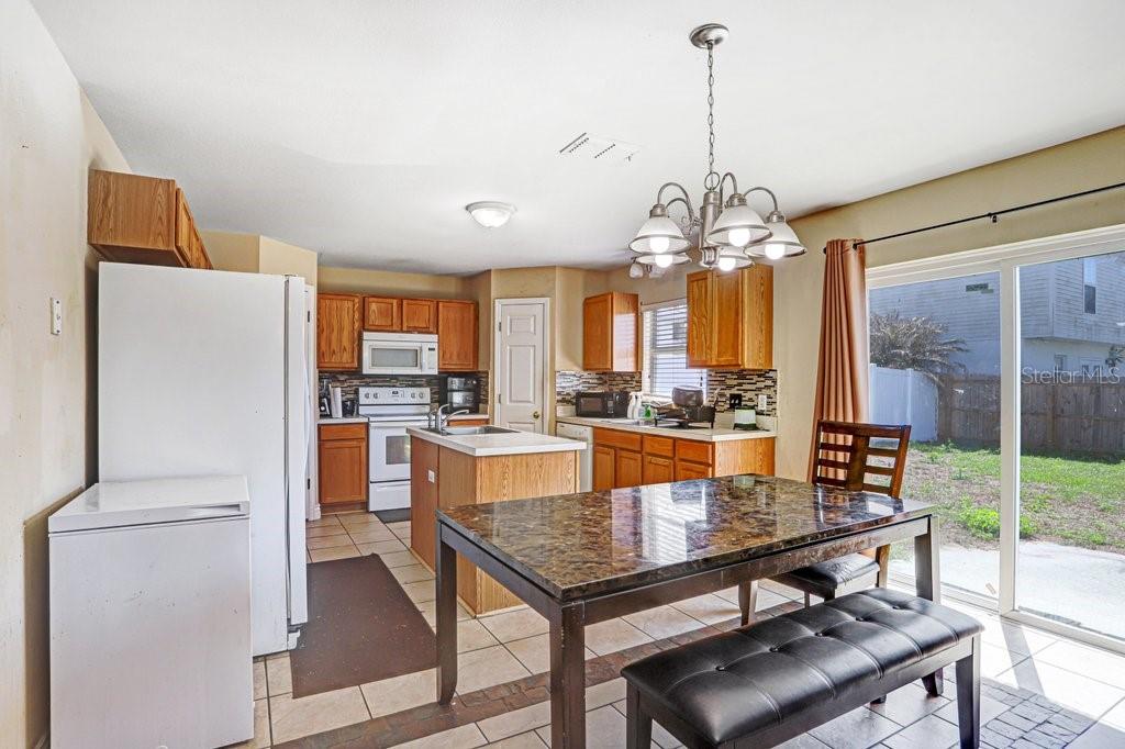 Dining area with view into kitchen, sliding doors to back yard and view into living area