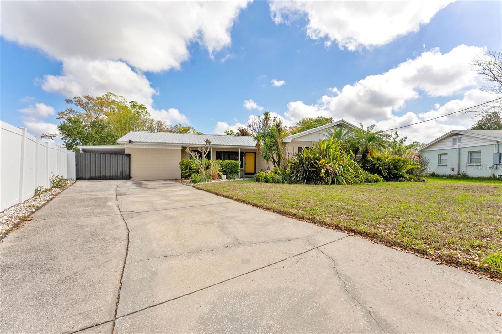 Extra long driveway that leads to carport that can hold 2 cars and detached garage