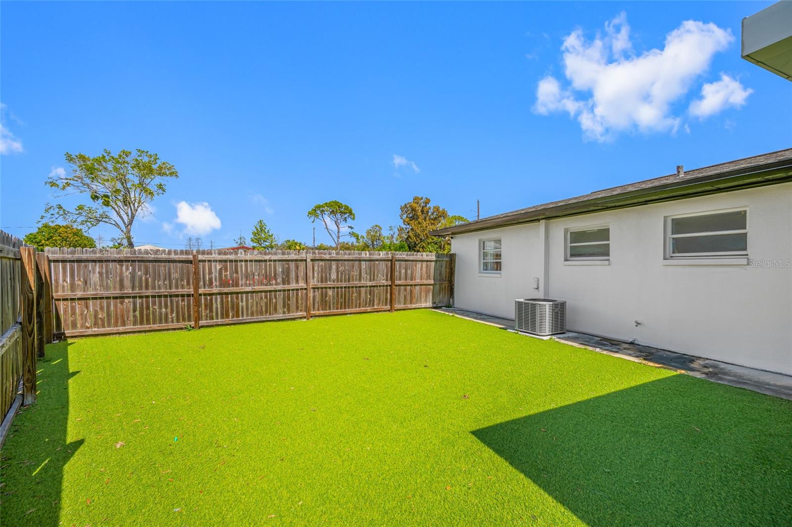 Fenced Backyard with faux grass