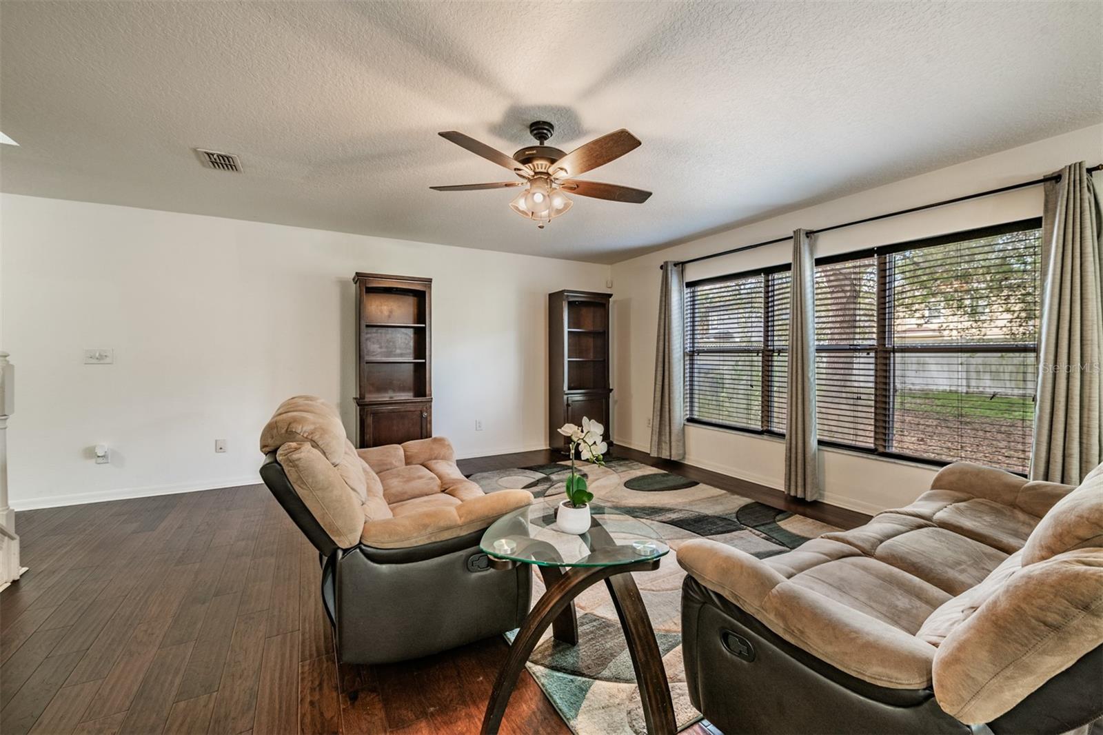 Large Family Room, lots of natural sunlight, engineered hardwood flooring, ceiling fan.