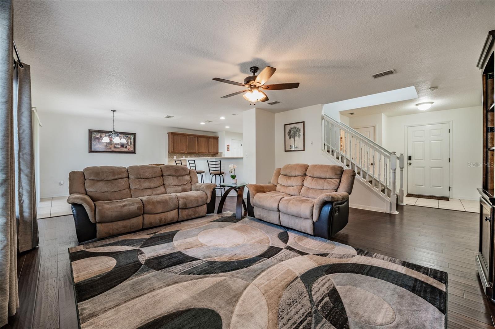 Large Family Room, lots of natural sunlight, engineered hardwood flooring, ceiling fan.