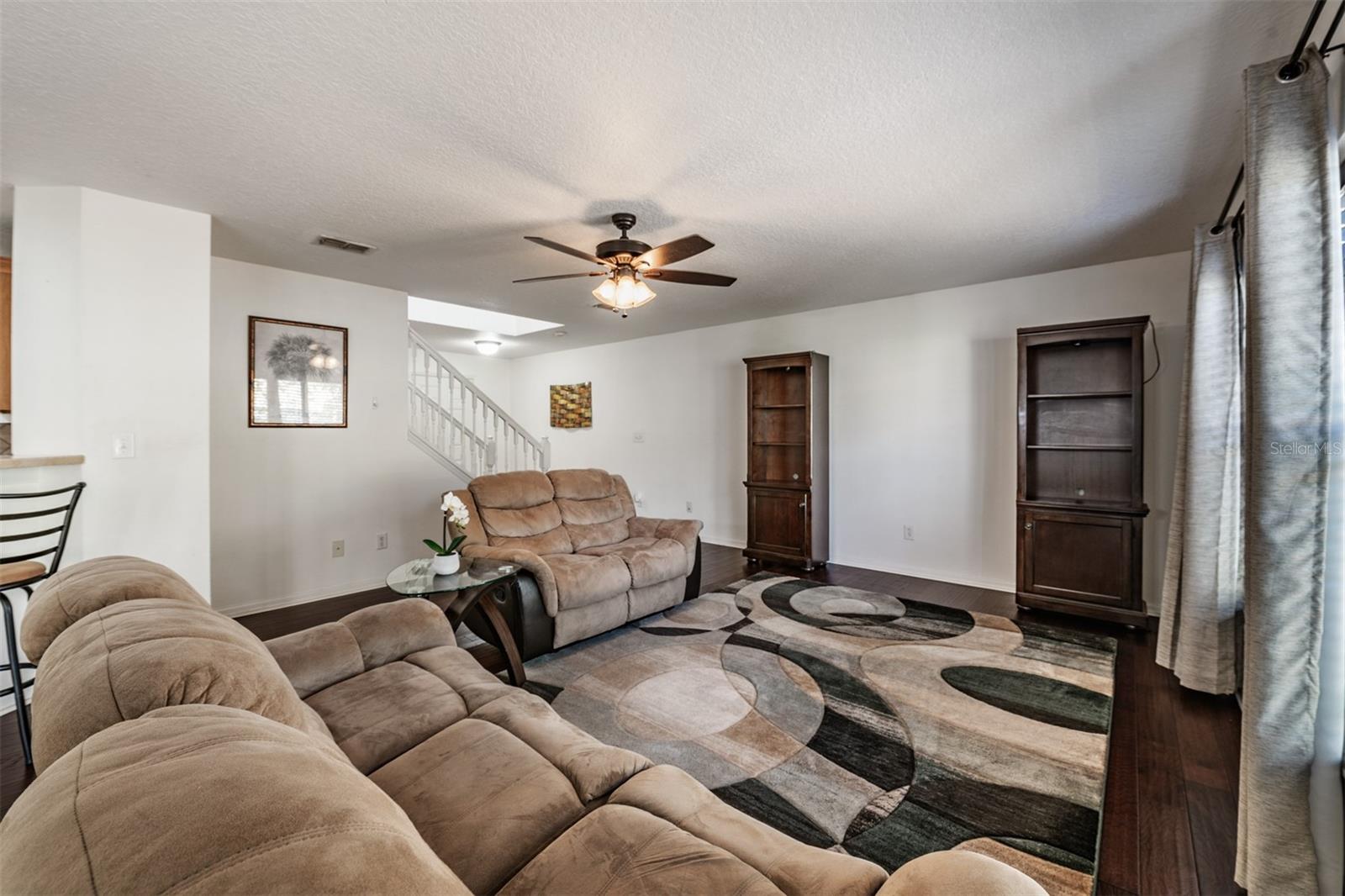 Large Family Room, lots of natural sunlight, engineered hardwood flooring, ceiling fan.