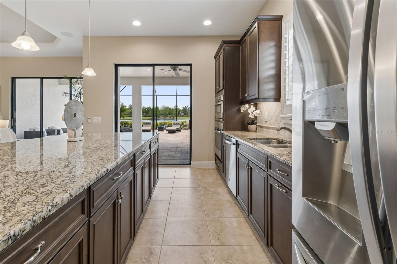 Open sightlines from the kitchen to the outdoor living space and peaceful water backdrop.