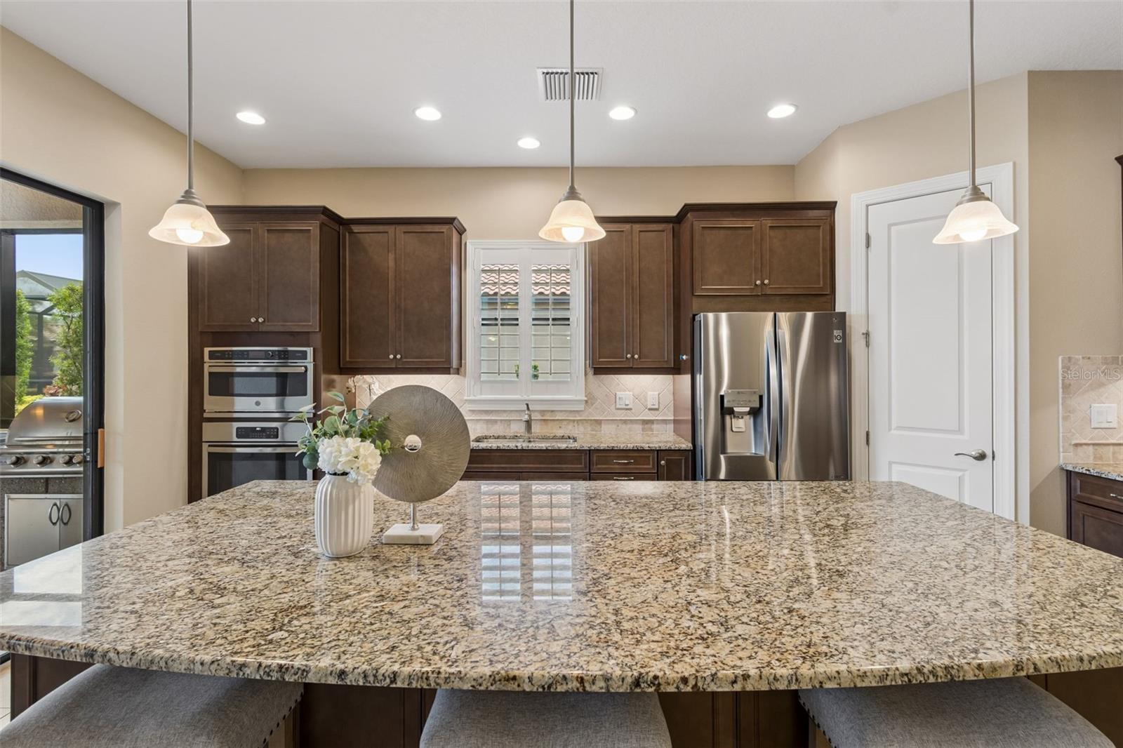 Cook inside, or out thanks to the added summer kitchen and covered, and extended lanai.