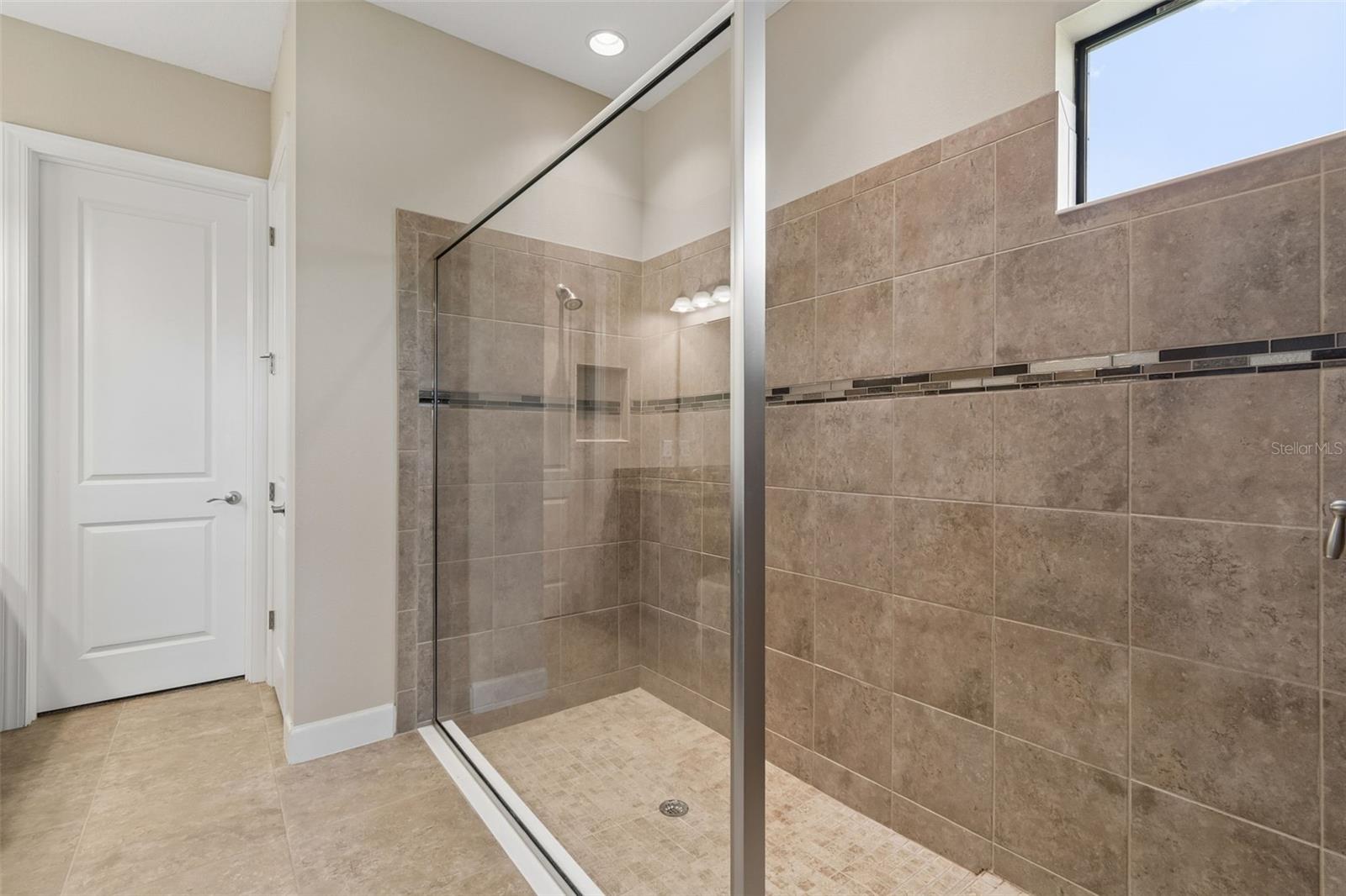 Spacious primary bath with walk-in shower and dual vanities.