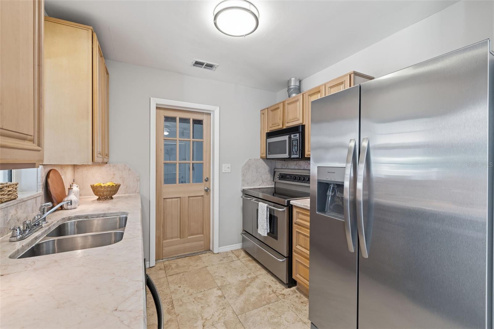 Kitchen with stainless steel refrigerator and generous counter space.