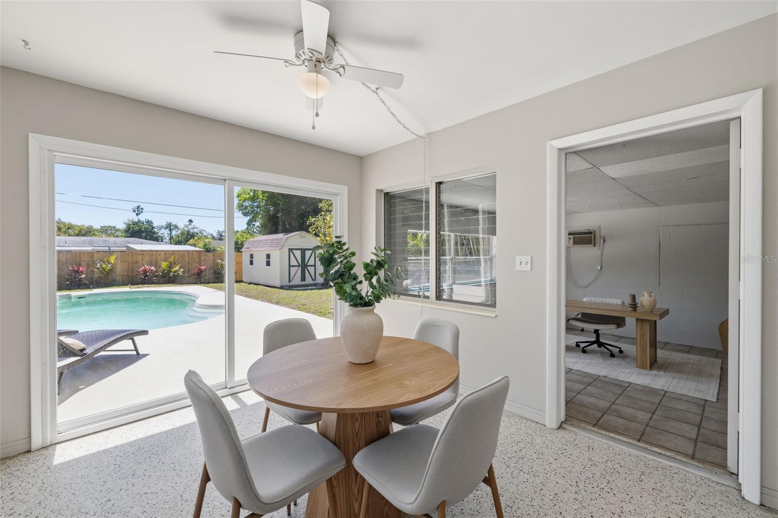 Dining space with original terrazzo flooring and views of the pool.