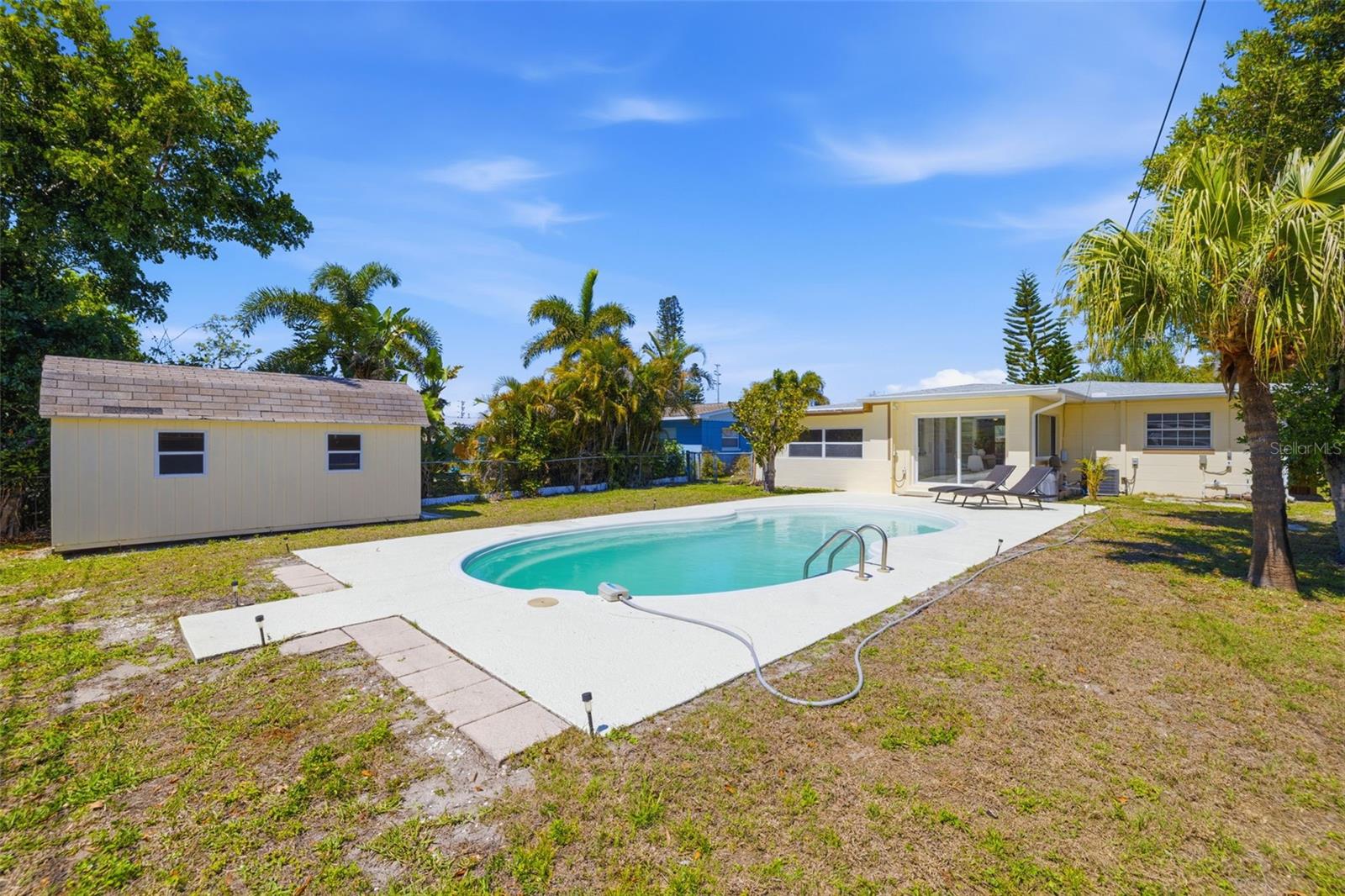 Wide view of the backyard showcasing pool and open space.