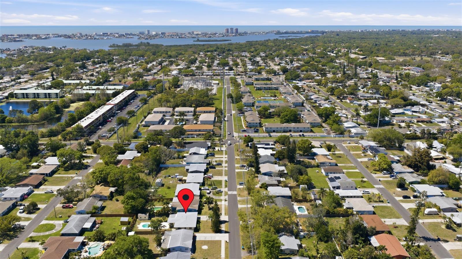 Extended aerial highlighting neighborhood layout and nearby coastal landscape.