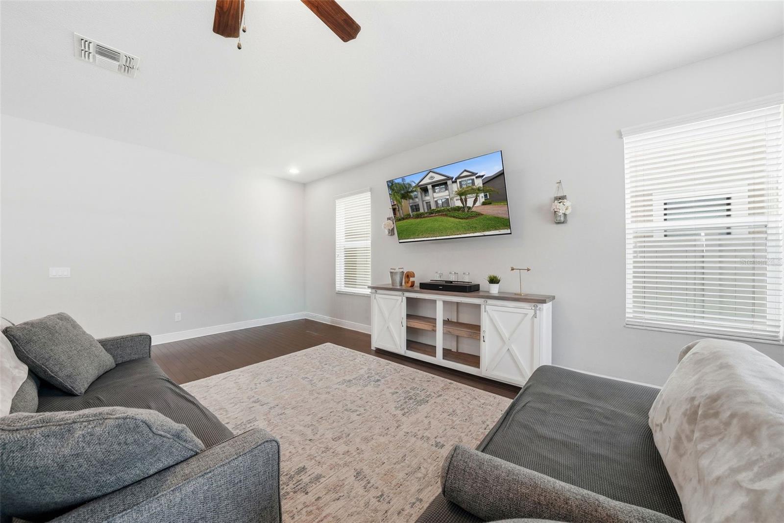 The main living room flows seamlessly just off the kitchen, creating a central gathering space perfect for everyday living and entertaining. Anchored by beautiful hardwood flooring, this open-concept area offers both comfort and style while keeping you connected to the heart of the home.