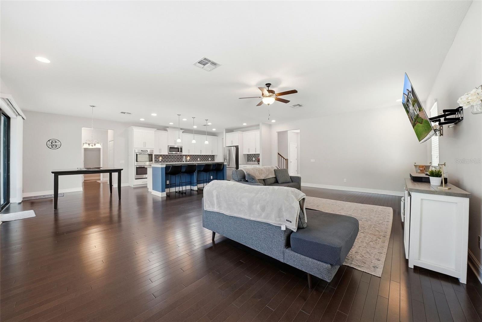 The main living room flows seamlessly just off the kitchen, creating a central gathering space perfect for everyday living and entertaining. Anchored by beautiful hardwood flooring, this open-concept area offers both comfort and style while keeping you connected to the heart of the home.