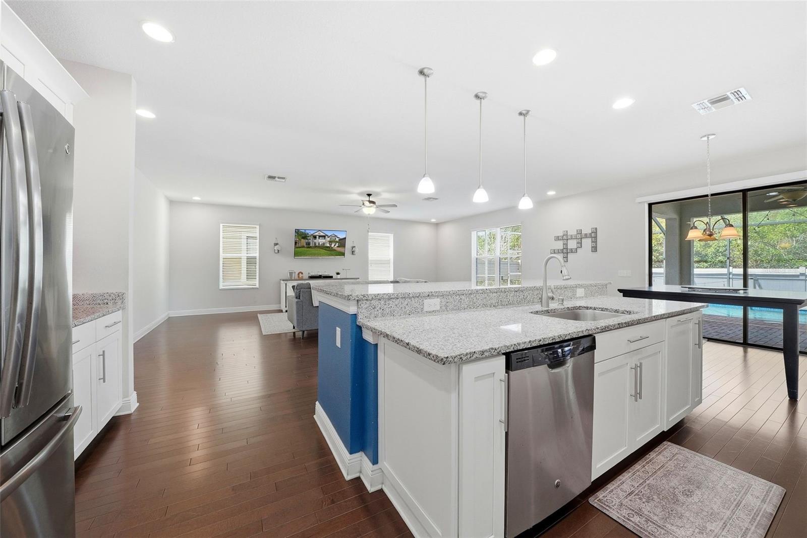 The kitchen is beautifully appointed with granite countertops, double ovens, and stainless steel appliances, all centered around an oversized island perfect for gathering and entertaining. A spacious pantry and abundant cabinetry provide exceptional storage, combining style and functionality in a truly impressive space.