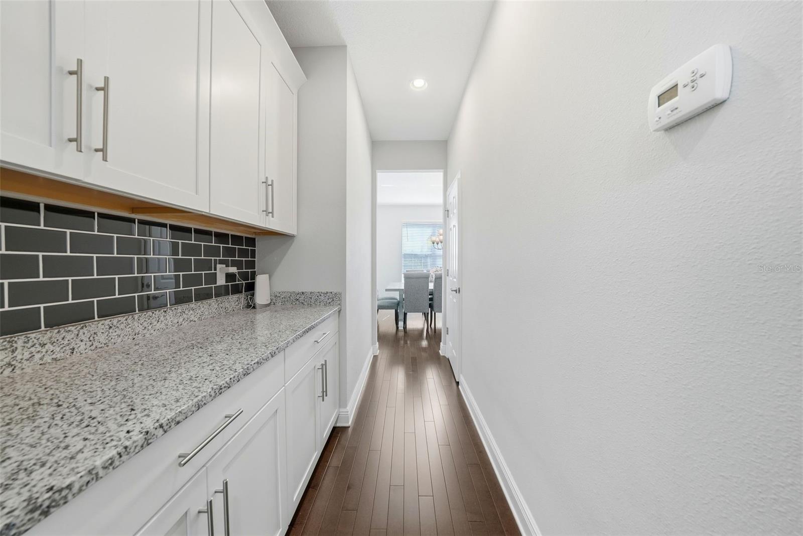 The kitchen is beautifully appointed with granite countertops, double ovens, and stainless steel appliances, all centered around an oversized island perfect for gathering and entertaining. A spacious pantry and abundant cabinetry provide exceptional storage, combining style and functionality in a truly impressive space.