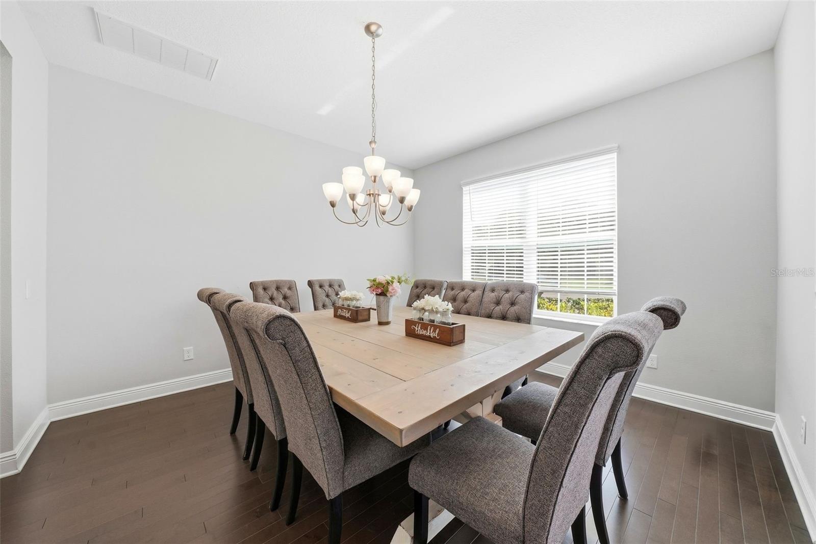 A formal dining area is ideally positioned just off the kitchen and to the right of the front entry, offering a seamless flow for both everyday meals and elegant entertaining while creating a warm and welcoming first impression.