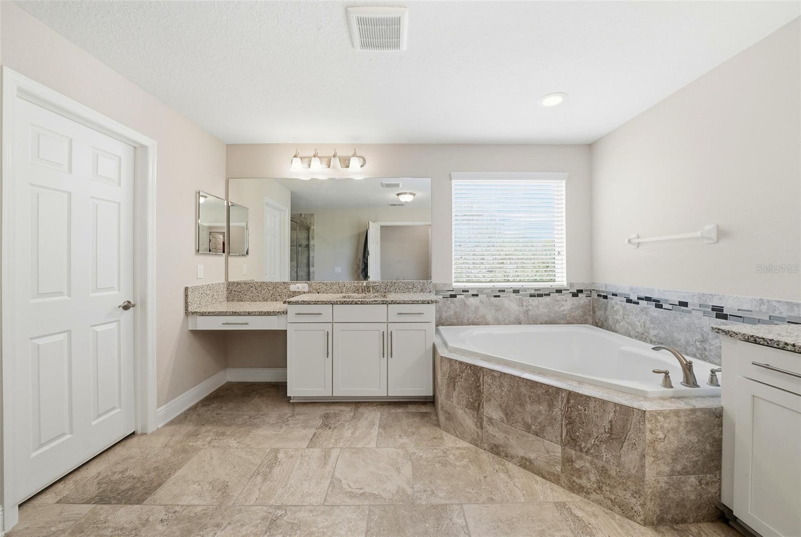 The en suite bathroom offers a private, spa-like retreat, thoughtfully designed for comfort and convenience with well-appointed finishes and a seamless connection to the Primary bedroom.