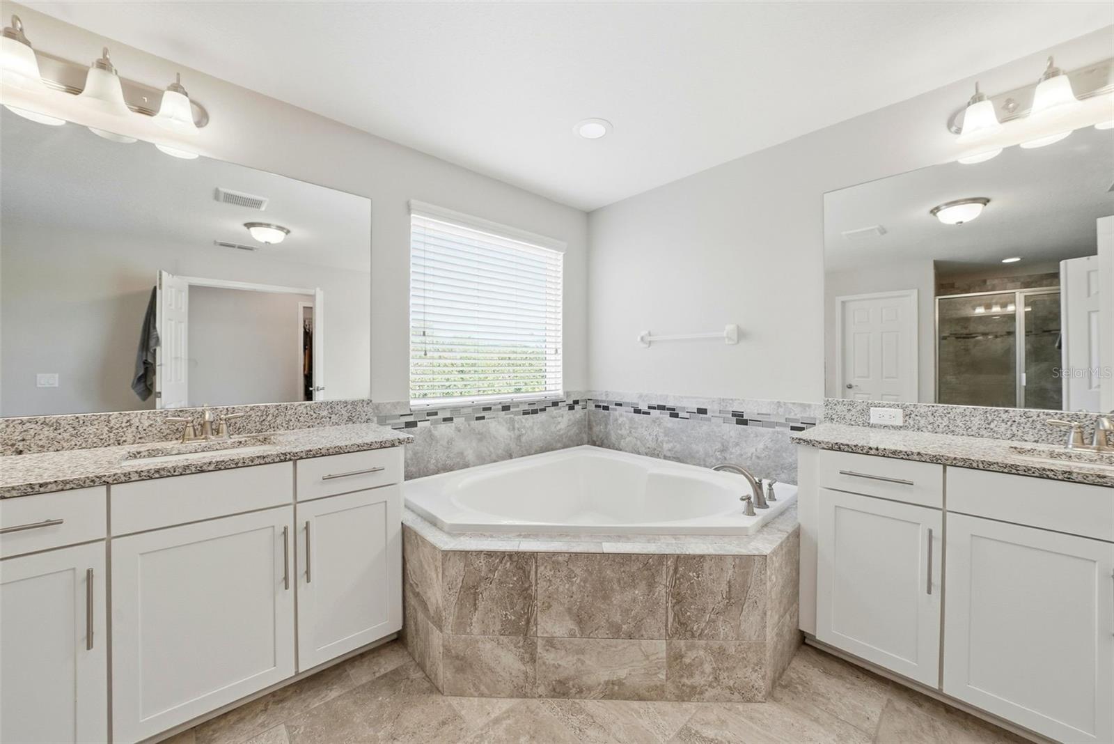 The en suite bathroom offers a private, spa-like retreat, thoughtfully designed for comfort and convenience with well-appointed finishes and a seamless connection to the Primary bedroom.