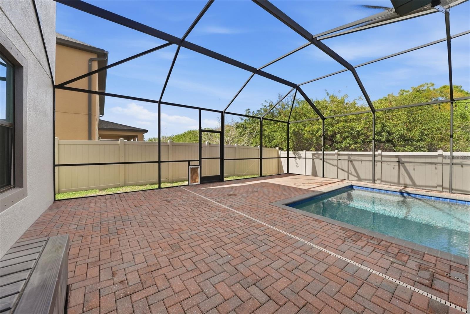 Enjoy your own private outdoor retreat featuring a screened-in lanai with elegant pavers, a heated pool and spa, and no rear neighbors—offering the perfect blend of comfort, privacy, and year-round relaxation.