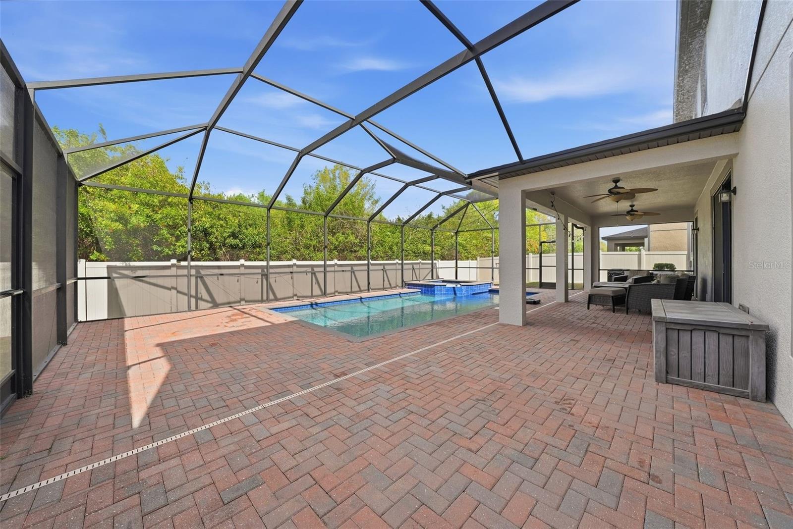 Enjoy your own private outdoor retreat featuring a screened-in lanai with elegant pavers, a heated pool and spa, and no rear neighbors—offering the perfect blend of comfort, privacy, and year-round relaxation.