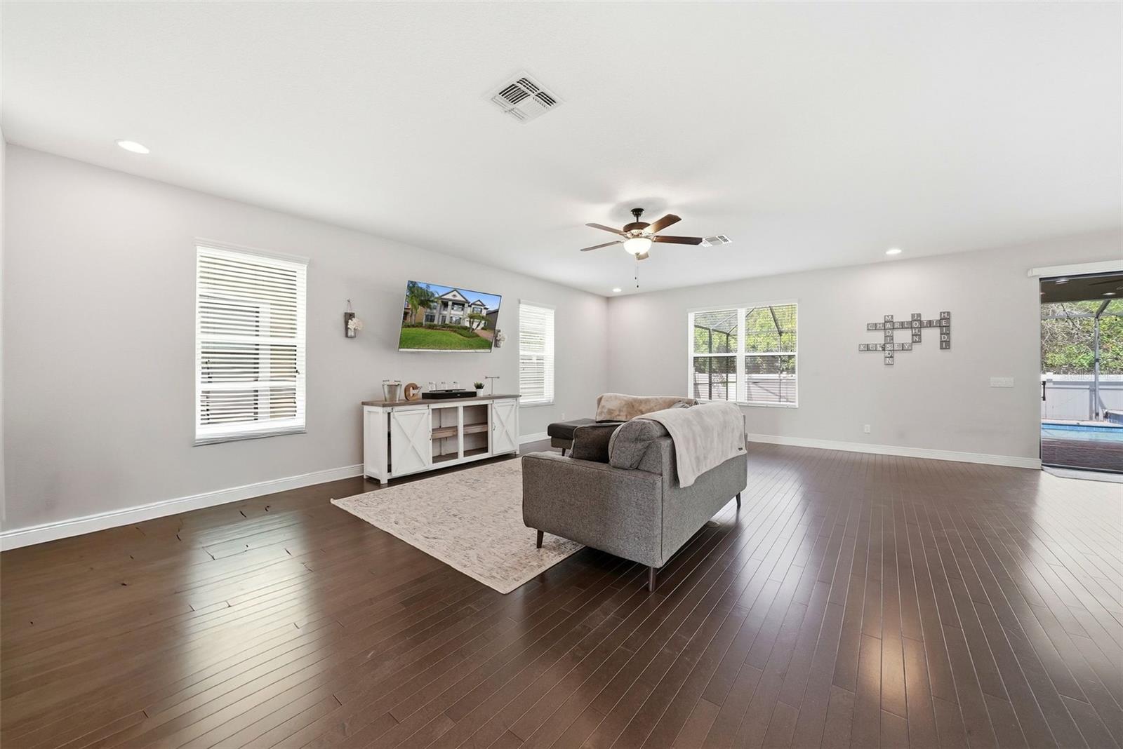 The main living room flows seamlessly just off the kitchen, creating a central gathering space perfect for everyday living and entertaining. Anchored by beautiful hardwood flooring, this open-concept area offers both comfort and style while keeping you connected to the heart of the home.