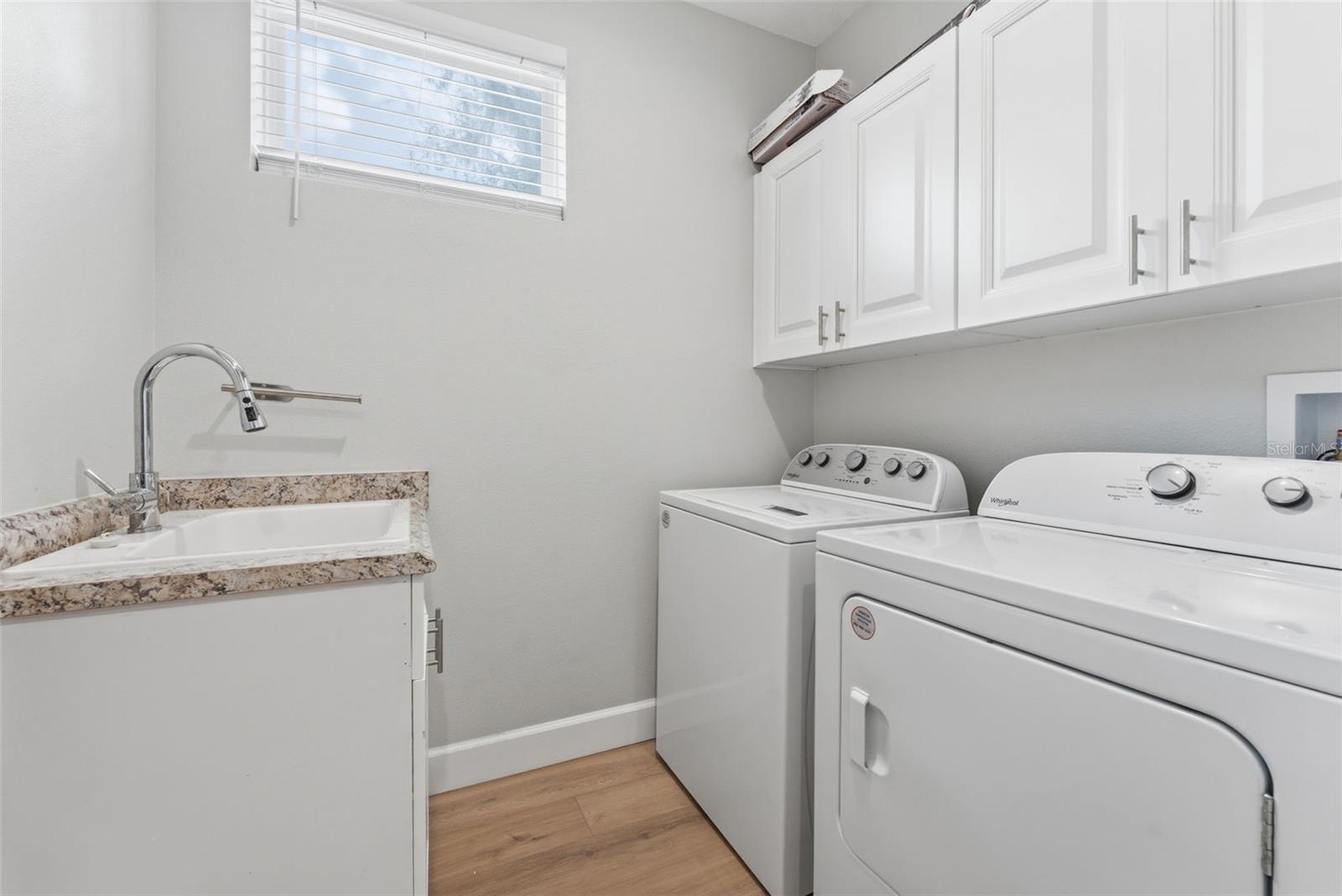 Upgraded laundry room with new sink and upper cabinets; large and deep storage closet not shown