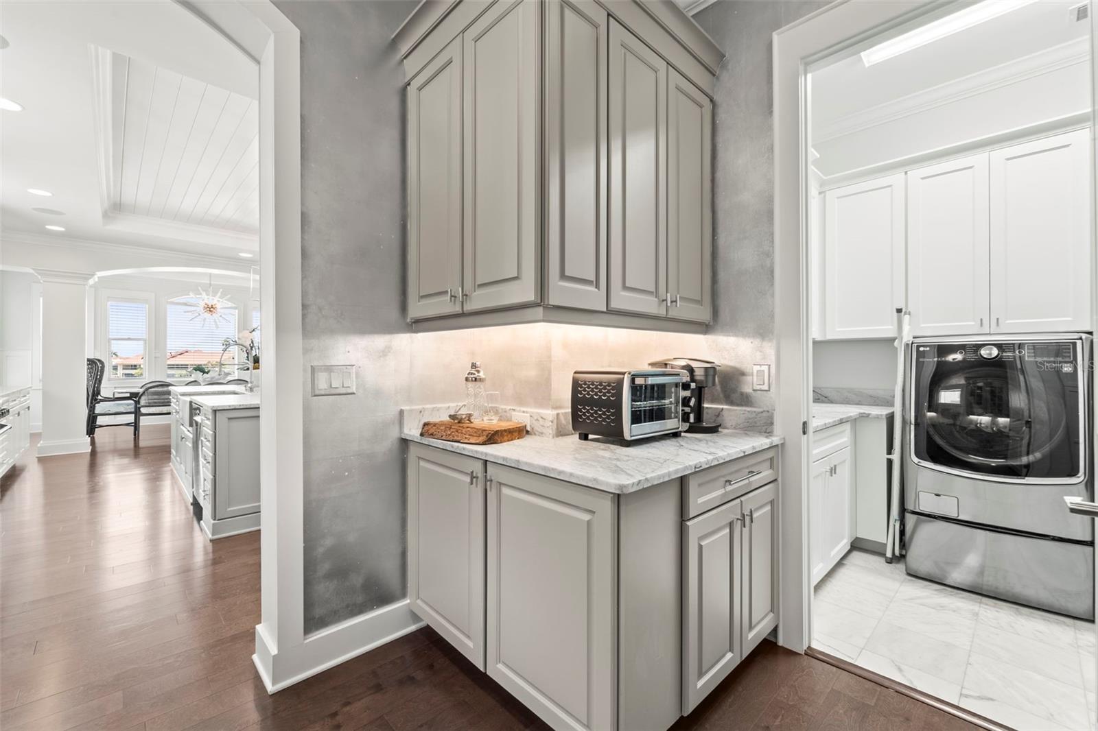 Additional view of the butler's pantry facing the kitchen and laundry room door, note custom millwork as well