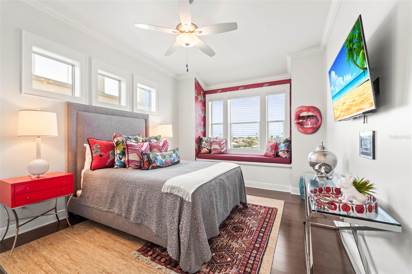 Bedroom 2 featuring a built-in window bench with beautiful water views, large windows, designer wallpaper, and private ensuite bath.