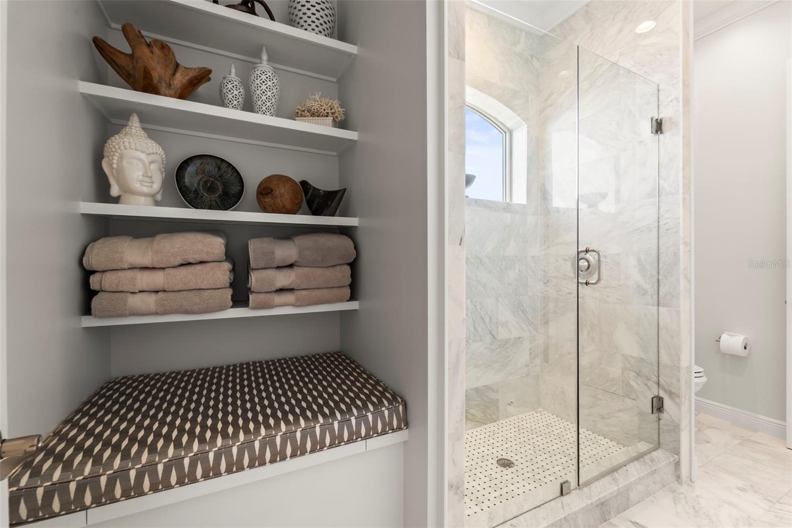 Shared shower and toilet area of the Jack-and-Jill bathroom with built-in shelving and bench with hidden storage.