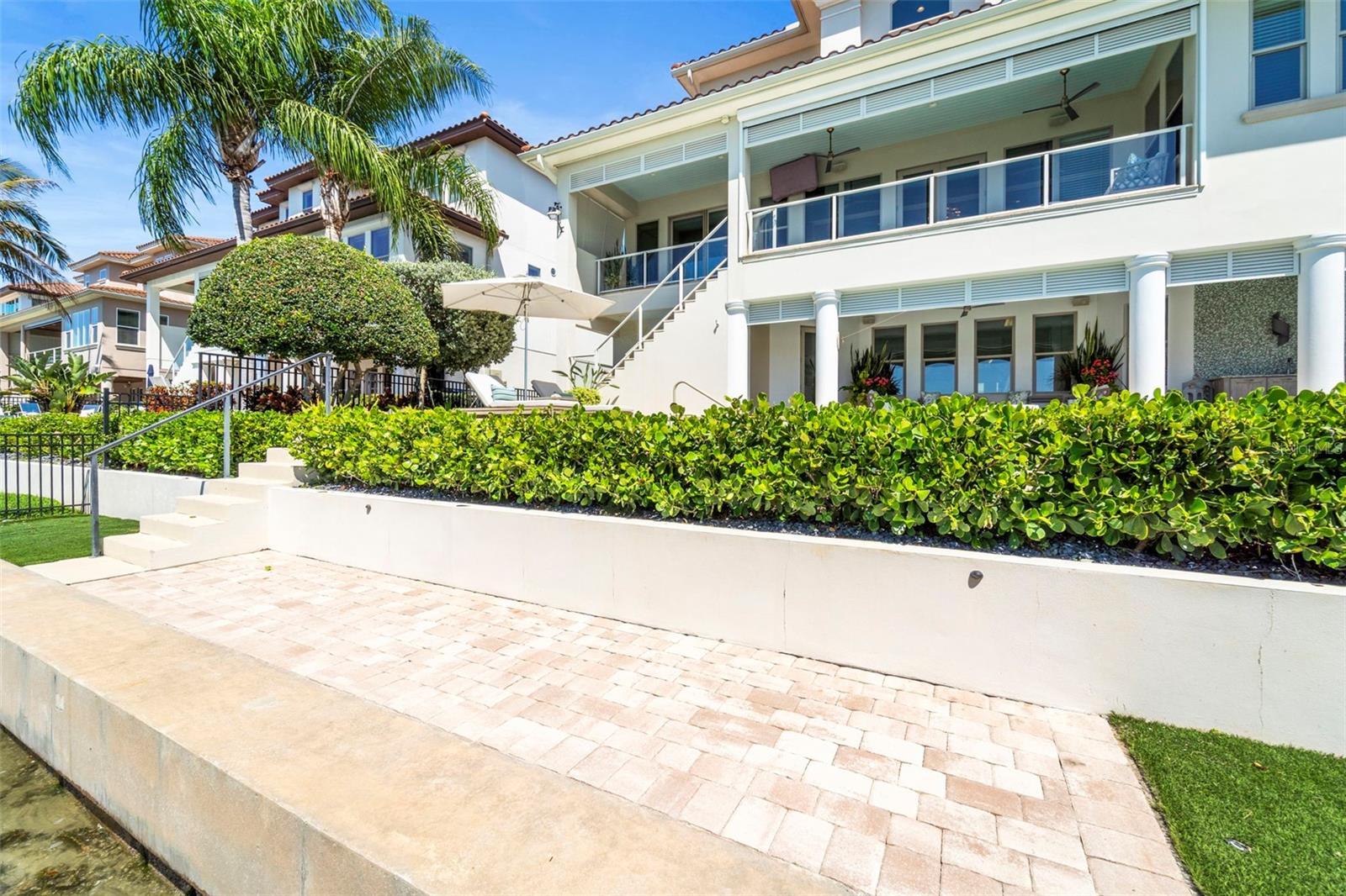 Property features 75 feet of waterfront with a durable concrete seawall less than 10 years old, the property is fenced at that level with turf grass and pavers