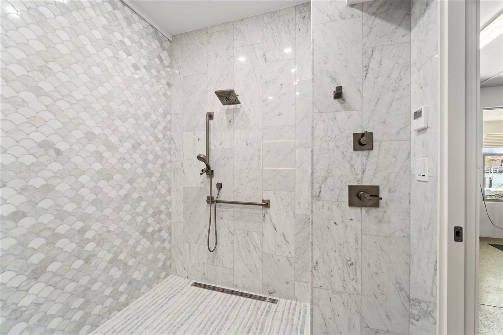 Marble-clad walk-in shower.