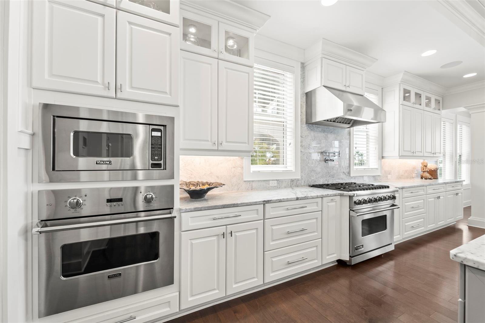 This kitchen is a chef's dream! Outfitted with premium gas-powered Viking appliances, including dual convection ovens, a professional six-burner cooktop, a built-in microwave & convenient pot filler for effortless cooking