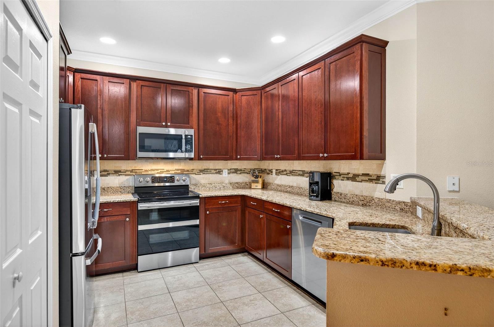 Kitchen features 42" cabinets with hardware and crown molding. Granite countertops and stainless steel appliances.