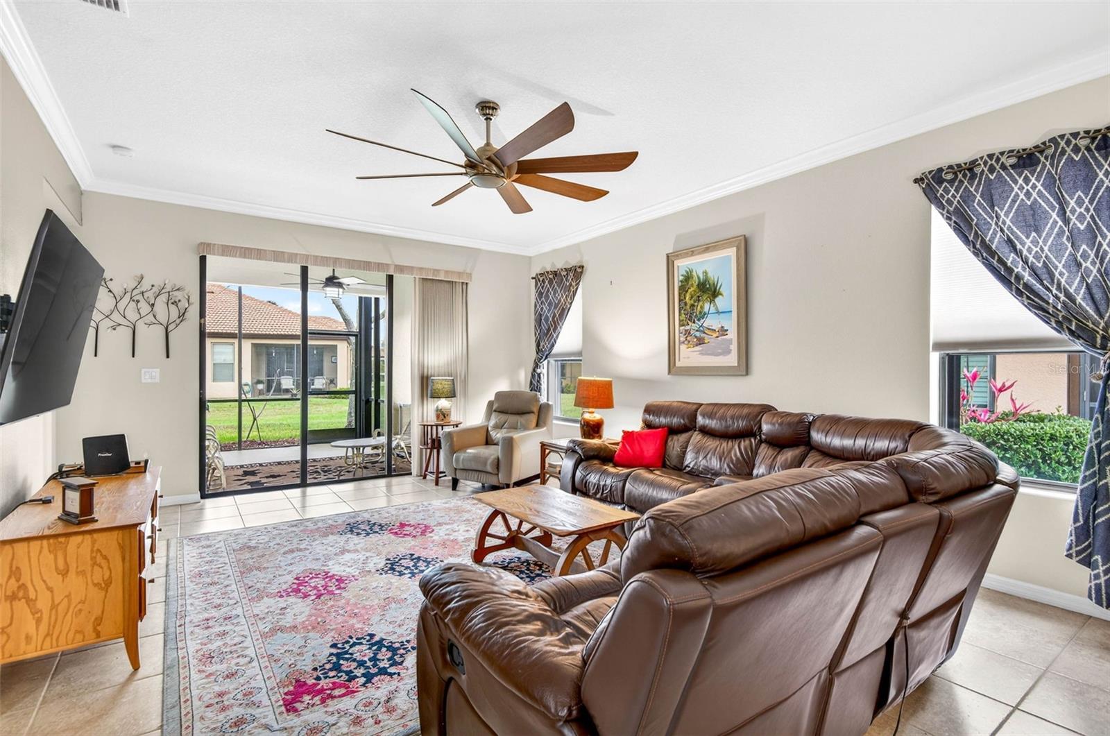 Family room complete with ceiling fan and crown molding. Large sliding glass doors bring in the outdoor views.